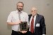 Dr. Nagib Callaos, General Chair, giving Mr. Ashley Dean a plaque "In Appreciation for Delivering a Great Keynote Address at a Plenary Session."